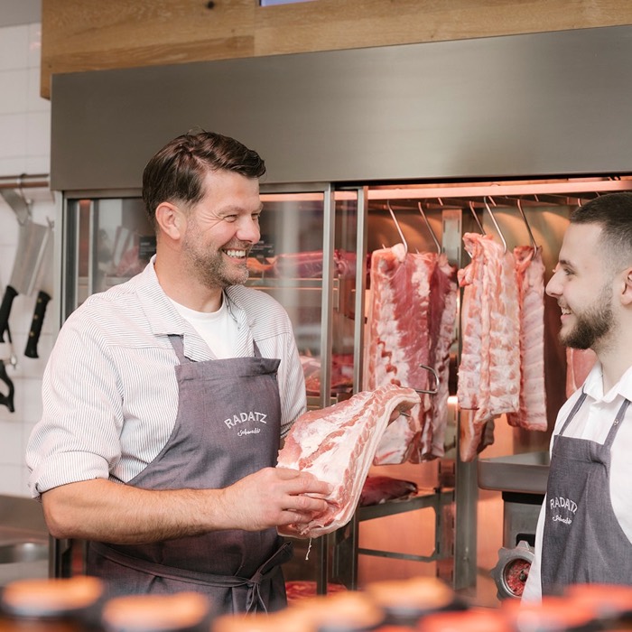 Radatz Mitarbeiter mit frischem Fleisch an der Theke